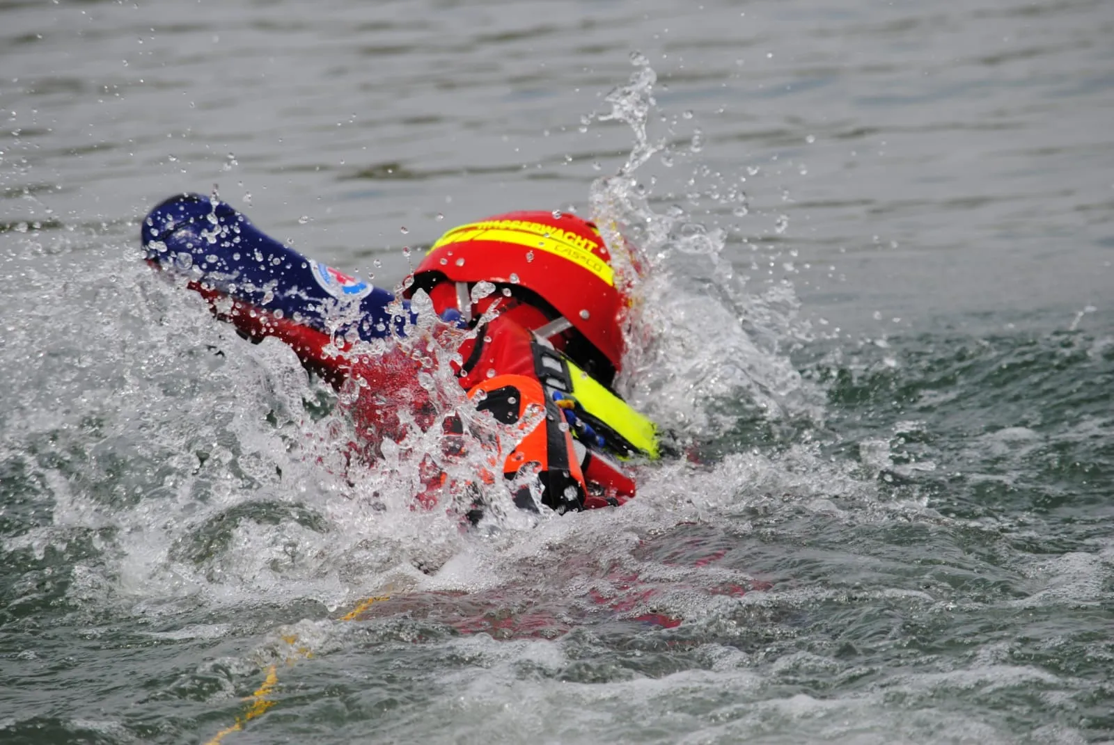 Wasserretter der Wasserwacht Regenstauf schwimmt mit Rettungsbrett durch die Gischt