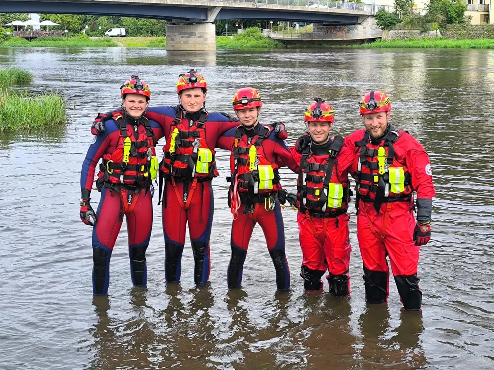 Fünf Einsatzkräfte der Wasserwacht Regenstauf Arm in Arm im Fluss
